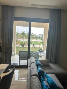 ein Wohnzimmer mit einem Sofa und einem großen Fenster in der Unterkunft Apartment in Hawana,Rotana in Ma‘mūrah