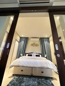 um quarto com uma cama grande e uma janela grande em Apartment in Hawana,Rotana em Ma‘mūrah