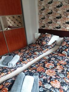 una camera da letto con un letto con copriletto floreale di Apartment Mestwina a Gdynia