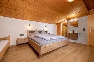 - une chambre avec un lit et un plafond en bois dans l'établissement Schiestl's Almstüberl, à Mayrhofen