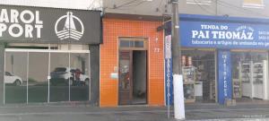 a store front with a car parked inside of it at Rex Hotel in Marília