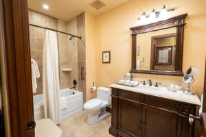 a bathroom with a sink and a toilet and a mirror at Hotel Granduca Houston in Houston