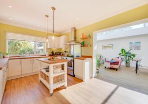 a kitchen with yellow walls and white cabinets at The Willows in Bromeswell