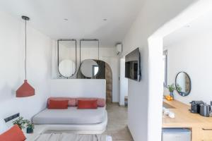 a living room with a couch and two mirrors at Enalios sunset suites in Naxos Chora