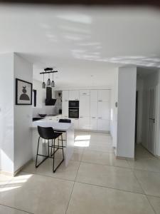 a kitchen with white cabinets and a table and chairs at Charmante Villa moderne in Pornichet