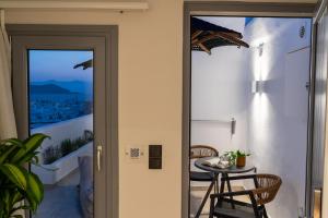 a door leading to a balcony with a table at Enalios sunset suites in Naxos Chora