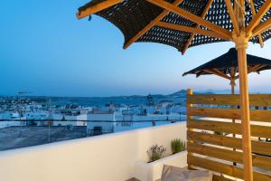 a view from the balcony of a house with a large umbrella at Enalios sunset suites in Naxos Chora