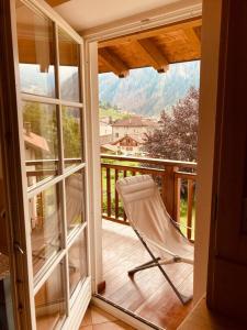 a chair on a balcony with a view of a mountain at Appartamento Mazzini in Predazzo