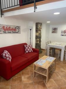 een woonkamer met een rode bank en een tafel bij Casa trinità in Catania