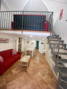 a living room with a red couch and a staircase at Casa trinità in Catania