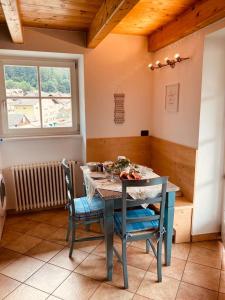 een eetkamer met een tafel en stoelen en een raam bij Appartamento Mazzini in Predazzo