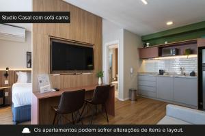 een hotelkamer met een bed en een bureau met stoelen bij Charlie For You Vila Mariana in Sao Paulo
