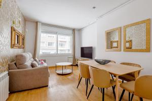 ein Wohnzimmer mit einem Tisch und einem Sofa in der Unterkunft Alcam Gold in Barcelona