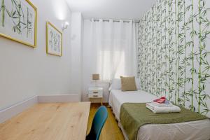 - une petite chambre avec 2 lits et une table dans l'établissement Alcam Gold, à Barcelone