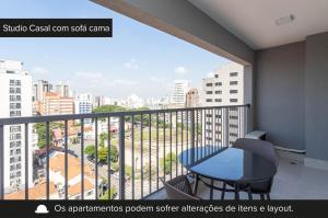 een balkon met een tafel en uitzicht op de stad bij Charlie For You Vila Mariana in Sao Paulo