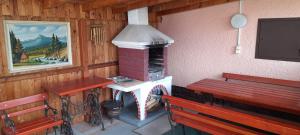 Un porche con dos bancos y una chimenea en una cabaña. en Privat Zuzka, en Liptovský Mikuláš