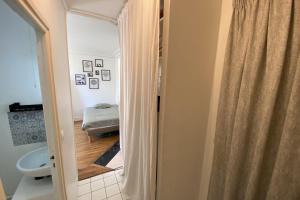 ein Bad mit einem Duschvorhang und einem Bett in der Unterkunft Cozy love nest near the Seine in Issy-les-Moulineaux