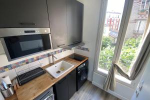 uma pequena cozinha com um lavatório e uma máquina de lavar louça em Cozy love nest near the Seine em Issy-les-Moulineaux