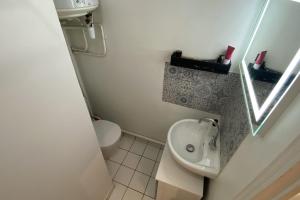 een kleine badkamer met een wastafel en een toilet bij Cozy love nest near the Seine in Issy-les-Moulineaux