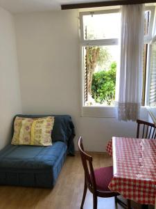 a living room with a couch and a window at Dragana in Petrovac na Moru +5 photos