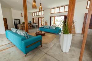 uma sala de estar com cadeiras azuis e uma mesa em Villa Binn by Kabana em Praia do Preá