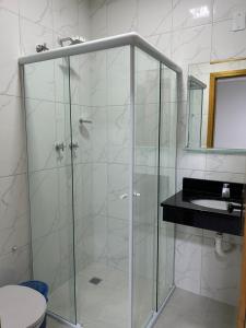y baño con ducha de cristal y lavabo. en Hotel Beirut, en Aparecida