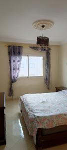 1 dormitorio con cama y ventana en FOUNTY APPARTEMENT DREAMS, en Agadir