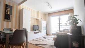 uma sala de estar com um sofá, uma mesa e uma televisão em Apartamento en el centro con plaza de garaje em A Guarda