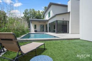 a house with a swimming pool and a lawn at Walk to Soco Lounge Poolside at Modern Cool Spot in Austin