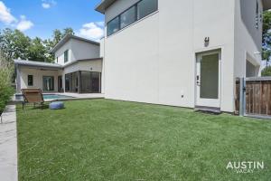 a backyard of a house with a green lawn at Walk to Soco Lounge Poolside at Modern Cool Spot in Austin