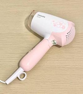 un asciugacapelli elettrico rosa e bianco su un tavolo di 6-10 Pax @ The CoZySpacious House - Heart Of Sunway a Petaling Jaya