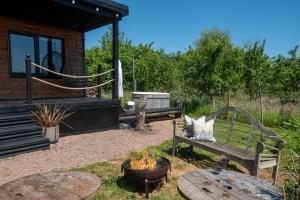 a patio with a bench and a fire pit at Bastle Retreats Cabin with hot tub in Duns
