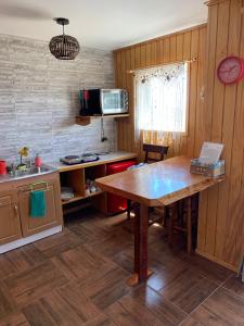 a kitchen with a wooden table in a room at Suite Matrimonial 2 Rocas del Mar in Pichilemu