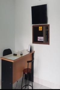 Camera con scrivania e TV a parete. di SPOT ON 92749 As-sakinah Syariah 2 a Medan
