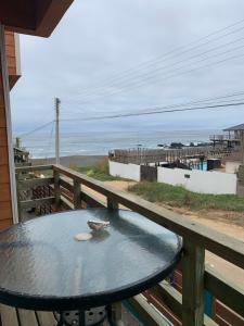 a table on a balcony with a view of the beach at Suite Matrimonial 2 Rocas del Mar in Pichilemu +7 photos