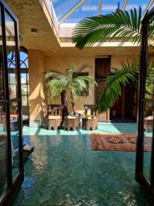 een kamer met 2 palmbomen en een zwembad met water bij B&B Agrabah, 1001 nights in Lomm