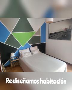 Habitación con cama y pintura en la pared en Apartamento Turistico Dct. Creus, en Guadalajara