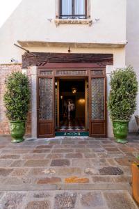 een toegang tot een gebouw met twee potplanten bij Palazzo Keller in Venetië