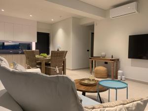 Ayïa suites في اليكاناس: غرفة معيشة مع أريكة وطاولة