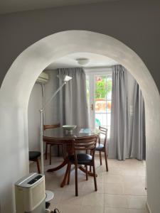 uma sala de jantar com uma mesa e cadeiras e uma janela em Errika's home near Athens Airport em Spata