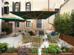 a patio with chairs and a table and an umbrella at Palazzo Keller in Venice