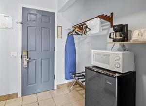 a door to a kitchen with a microwave and a refrigerator at Sol Springs Inn in Palm Springs