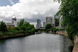 un río en medio de una ciudad con edificios en StayInn Stratford, en Londres