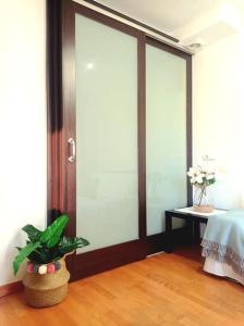 um quarto com uma porta de vidro deslizante com uma planta em Acogedor apartamento con piscina y garaje em Huesca