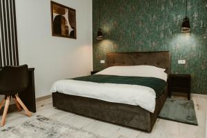 a bedroom with a bed and a green wall at ARINI WHITE HOUSE in Sibiu