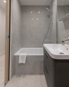 a bathroom with a bath tub and a sink at StayInn Stratford in London