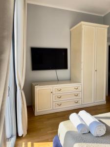 uma sala de estar com televisão e uma cómoda com televisão em Sweet Home Desiree em Florença