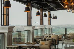 STwin Hotel في أبها: مطعم بطاولات وكراسي ونوافذ