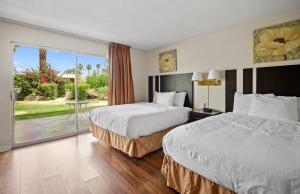 a hotel room with two beds and a large window at Sol Springs Inn in Palm Springs +12 photos
