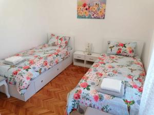 a bedroom with two beds and a table and a picture at Apartment & Rooms Lilis in Izola